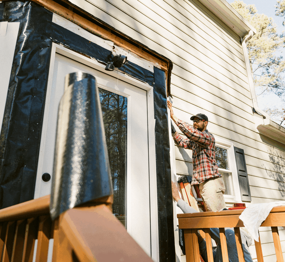 Man working on house exterior renovation.